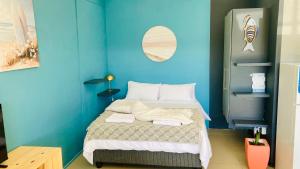 a blue room with a bed with towels on it at Luxury Smart Studio - Sea and Mountain Views - Gordon's Bay in Gordonʼs Bay