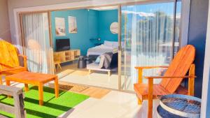 a room with chairs and a room with a bedroom at Luxury Smart Studio - Sea and Mountain Views - Gordon's Bay in Gordonʼs Bay