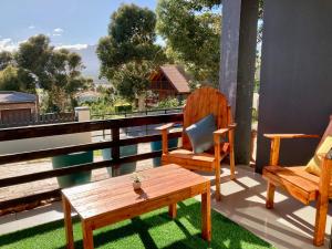 a porch with two chairs and a bench and a table at Luxury Smart Studio - Sea and Mountain Views - Gordon's Bay in Gordonʼs Bay