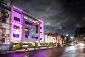 墨西哥城的住宿－Hotel Villa del Mar，夜幕降临的城市街道上的紫色建筑