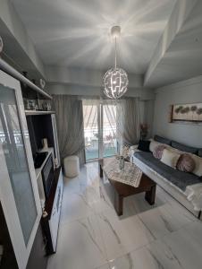 a living room with a couch and a tv at EV Apartment with free parking place in Volos