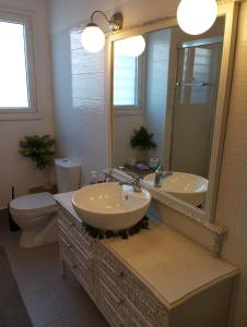 a bathroom with two sinks and a toilet and a mirror at SG House in Bolátion +29 photos