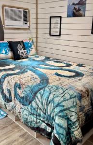 a bedroom with a bed with a comforter on it at Camp Squid Off The Grid in Benzonia +42 photos