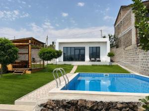 ein Garten mit Swimmingpool und ein Haus in der Unterkunft White Location in Dzoraghpʼyur