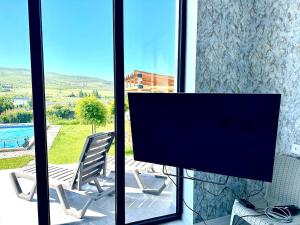 ein Flachbildfernseher vor einem Fenster in der Unterkunft White Location in Dzoraghpʼyur