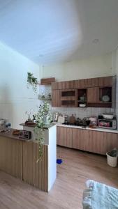 a kitchen with wooden cabinets and a counter in a room at Dune House Phan Thiết in Ấp Bình Hưng
