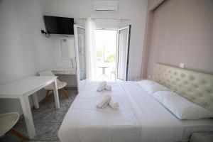 a bedroom with a large white bed with two white towels at Studio Mary in Perissa