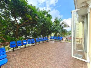a row of blue chairs sitting on a patio at Emerald Inn Karawaci in Dungus +11 photos