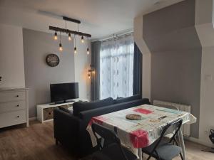 a living room with a table and a couch at 1 Le Cocon Mosaïque Centre-ville in Ernée