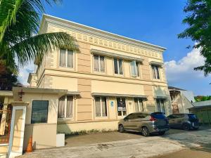 a building with two cars parked in front of it at Emerald Inn Karawaci in Dungus