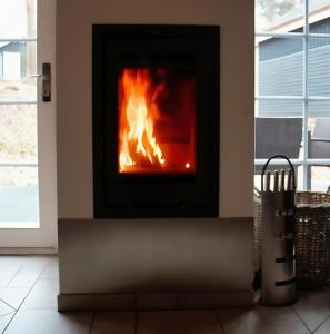 a fireplace in a living room with a fire in it at Feenwald - Baabe in Baabe