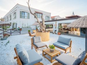 a patio with chairs and tables and a tree at Marge Hotel Adult Only 12 plus in Ilıca