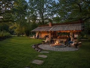 a group of people sitting around a fire pit in a yard at Zacisze pod Śnieżką in Mysłakowice