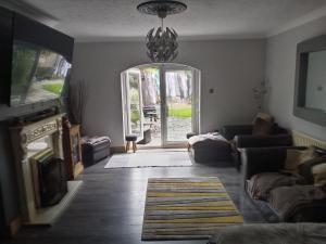 a living room with a couch and a chandelier at Strawberry dream 2 in Newcastle upon Tyne