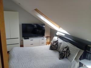 a bedroom with a bed with a television and pillows at Strawberry dream 2 in Newcastle upon Tyne