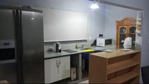 a kitchen with a stainless steel refrigerator and white cabinets at Quincho Paysandu in Arroyo Seco