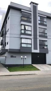 a large white building with a street in front of it at Little Britain no centro de Pomerode in Pomerode