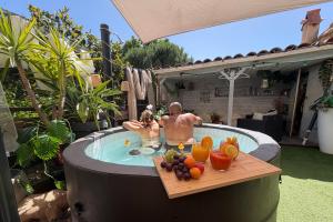 two people in a hot tub with fruit in it at Le Magnolia in Canet