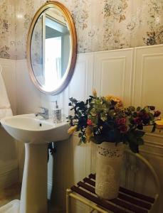 a bathroom with a sink and a mirror and a vase with flowers at Oryx Homes & Villas in Bodrum City +26 photos