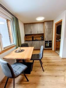 a kitchen and dining room with a wooden table and chairs at Haus Gstrein in Oetz
