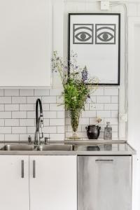 a kitchen with a sink and a vase of flowers at Historic lakeside villa - sauna, ski, boat, 20 guests in Sunnansjö