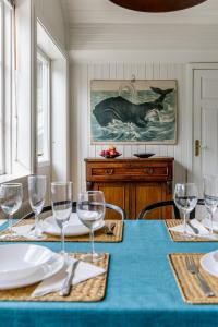 a dining room table with a blue table cloth and glasses at Historic lakeside villa - sauna, ski, boat, 20 guests in Sunnansjö