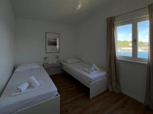 ein kleines Zimmer mit zwei Betten und einem Fenster in der Unterkunft Apartment Rose in Rogač