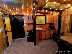 a kitchen with a black refrigerator and wooden cabinets at Cabaña Nido de Niebla en San José del Pacífico in San Jose del Pacifico
