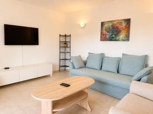 a living room with a blue couch and a table at Casa Sol Maris in Novigrad Istria