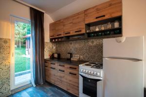 eine Küche mit Holzschränken und einem weißen Kühlschrank in der Unterkunft Vila Stanjevac, Sarajevo in Sarajevo