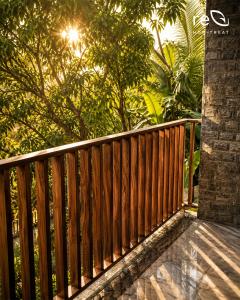 a wooden fence on a porch with trees in the background at Re-Leaf Hom-Treat Homestay in Wayanad