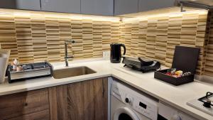 a kitchen counter with a sink and a dishwasher at White Bloom - Kfardebian 6836 in Kfardebian