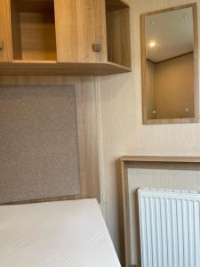 a bedroom with a bed and a mirror and a radiator at Drake 17 in Scarborough