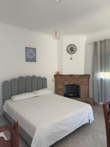 a bedroom with a large bed and a fireplace at Lalëz Villa Hoxha in Fushë-Draç