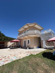 a large house with a balcony and a patio at Lalëz Villa Hoxha in Fushë-Draç