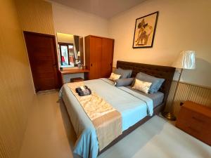 a bedroom with a large bed with blue sheets at Erindra Villa in Pesanggaran +7 photos