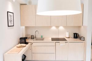 a small kitchen with white cabinets and a sink at Apartament Bukovy Wisła in Wisła +12 photos
