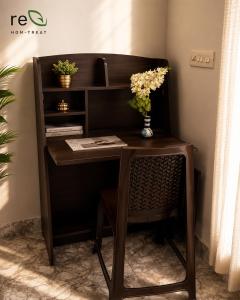 a wooden desk with a chair and flowers on it at Re-Leaf Hom-Treat Homestay in Wayanad