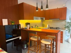 a kitchen with a counter with chairs and a sink at Erindra Villa in Pesanggaran