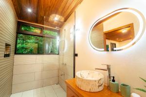 a bathroom with a sink and a mirror at Cabañas Hoja Verde in Monteverde Costa Rica