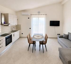a kitchen and living room with a table and chairs at Rrapi Apartments in Tragjas
