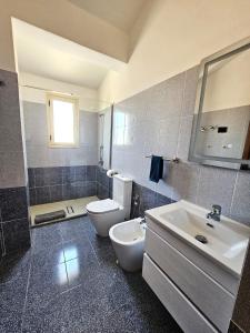 a bathroom with a white toilet and a sink at Rrapi Apartments in Tragjas +47 photos