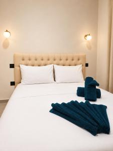 a white bed with two blue towels on it at Rrapi Apartments in Tragjas