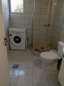 a bathroom with a washing machine and a toilet at Thassos Home in Skala Kallirachis +13 photos