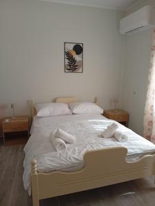 a bedroom with a bed with white sheets and pillows at Thassos Home in Skala Kallirachis
