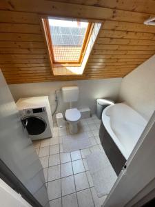 a bathroom with a tub and a toilet and a sink at Fefe Apartman in Balatonlelle +7 photos
