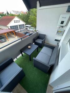 a balcony with two chairs and a table and a table at Fefe Apartman in Balatonlelle