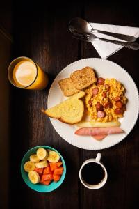 a plate of breakfast food with toast and a bowl of fruit at Hotel Ciudad de Segorbe in Salento