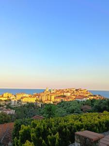 a view of a city with the ocean in the background at La Quercia Agriturismo in Imperia