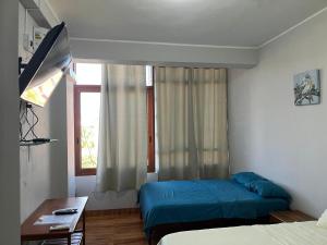 a hotel room with two beds and a window at Heliconia's Inn in Puerto Maldonado +13 photos